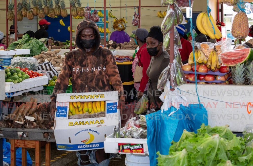Vendor Deyshorn Cooper carries a box of bananas to stock his stall at the Scarborough Market. -
File photo by David Reid