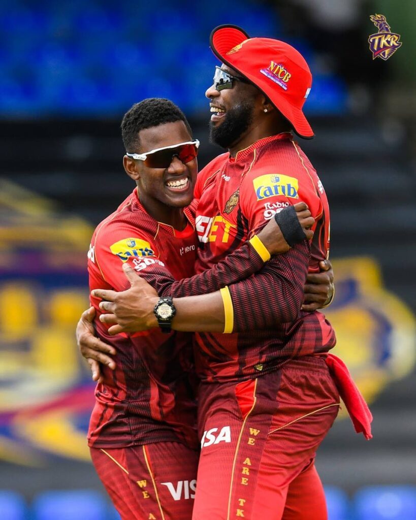 Trinbago Knight Riders captain Kieron Pollard, right, hugs his spinner Akeal Hosein during a CPL match. FILE PHOTO/TRINBAGO KNIGHT RIDERS - 