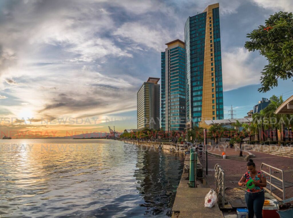 In this file photo, people fish near the Waterfront Complex, off Wrtightson Road, Port of Spain. The two towers houses government and judicial offices. The Hyatt Regency hotel is far left. - JEFF K MAYERS