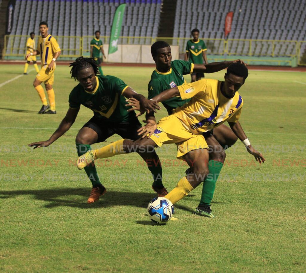Fatima's Khiba Romany, centre, is tackled by St Benedict's Ephraim Brown,left, and Joshua Demas during the 2022 Coca-Cola Intercol final. FILE PHOTO/ROGER JACOB - 