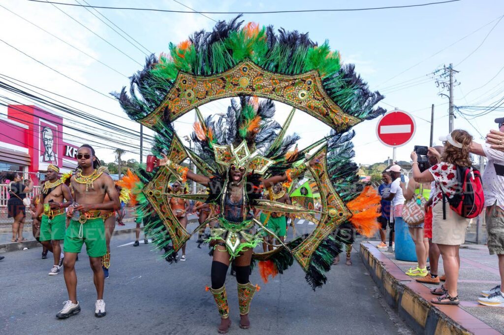 In this file photo a masquerader from Gloria Stoiute Creation portrays her costume during the parade of the bands along Milford Road, Scarborough. - Photo by David Reid