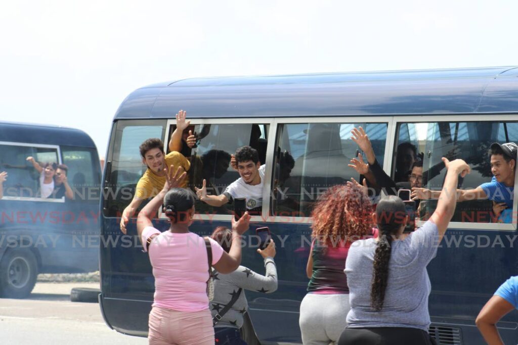 Venezuelan migrants wave to relatives as they are taken from the heliport at the Chaguaramas to be deported to Venezuela on August 12. - File photo/Grevic Alvarado