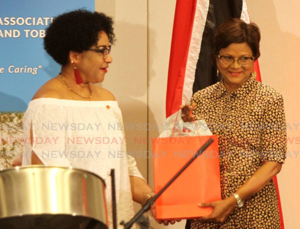 President Christine Kangaloo, right, receives a token from president of the Alzheimer's Association Michele Saunders-Clavery during the event at Hyatt Regency, Port of Spain on Saturday.   - Ayanna Kinsale