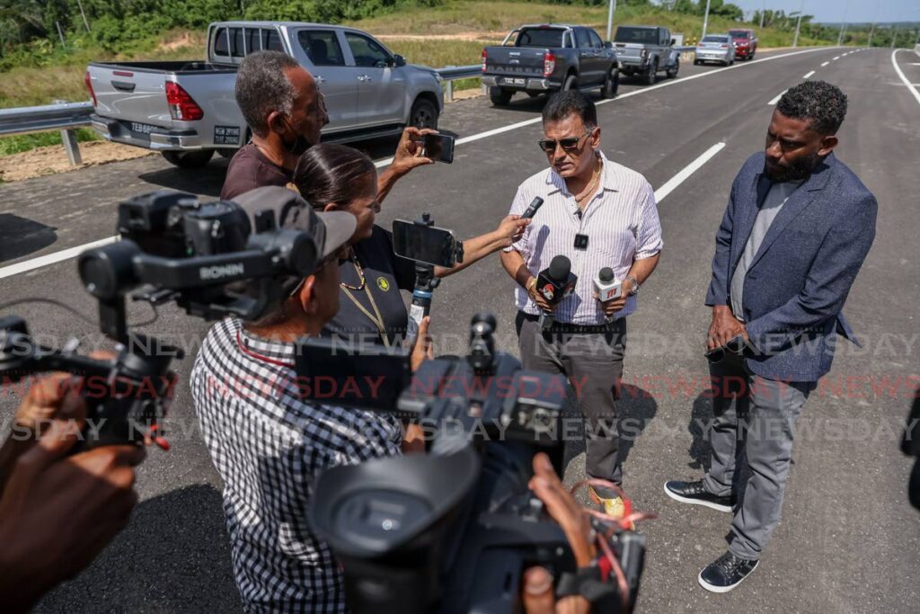 Minister of Works and Transport Rohan Sinanan, second from right, speaks to media alongside NIDCO programme manager Dennis Harricharan at the opening of Grant’s Road to La Brea Interchange section of the San Fernando to Point Fortin Highway on Sunday. - Photo by Jeff K. Mayers