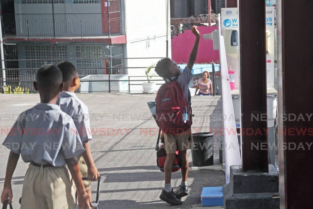 A student checks his temperature as he enters San Fernando Boys' RC School on Monday. - Lincoln Holder