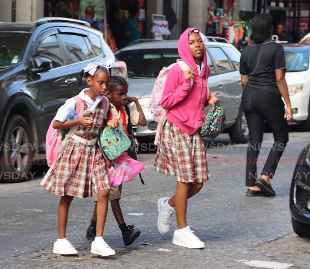 Primary School students walk on Broadway, Port of Spain, on their way home after the first day of school on Monday. - Angelo Marcelle