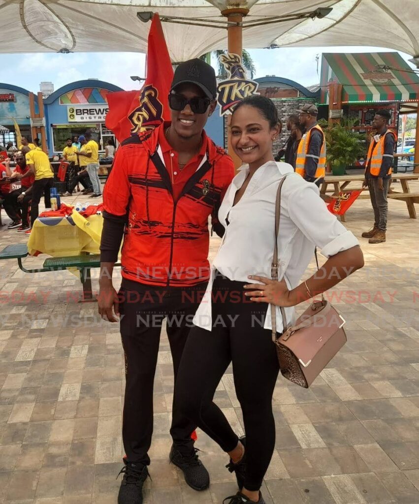 A Trinbago Knight Riders fan takes a picture with left-arm spinner Akeal Hosein upon the team's arrival at the Piarco International Airport on Monday morning.  - Photo by Roneil Walcott