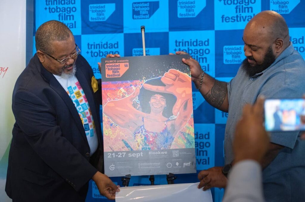 FILMCO chairman Derwin Howell, left, unveils the TT Film Festival 2023 poster designed by Newsday's graphic artist Warren Le Platte at the festival launch on September 4 at the VIP Lounge, Hasely Crawford Stadium, Port of Spain. Photo courtesy FILMCO - 