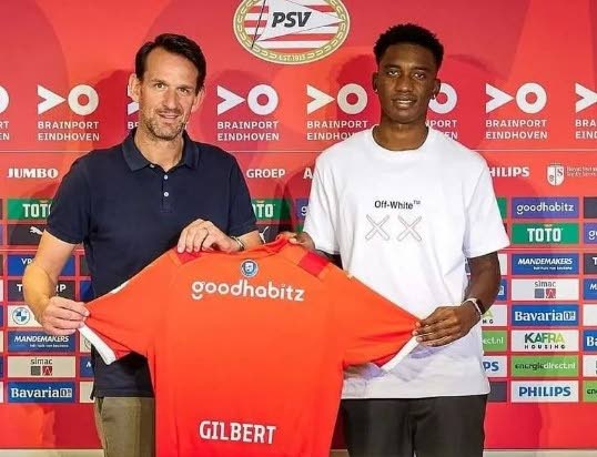 Trinidad and Tobago's Dantaye Gilbert, right, gets his PSV Eindhoven jersey after signing for the Dutch club.  - 