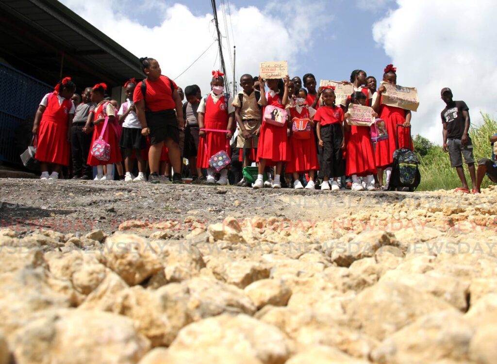 Students of the Caratal RC Primary School stand on the damaged road during a protest on Caratal Road, Gasparillo. - Photo by Ayanna Kinsale
