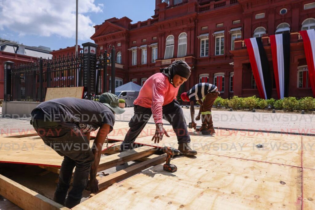 Workers construct a platform for the red carpet on Saturday ahead of the ceremonial opening of Parliament on Monday. - Jeff K. Mayers