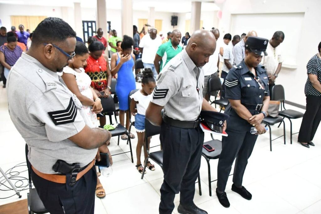 From left, Sgt Imraz Hosein, Sgt Gregory Joseph and Insp Adina Cummings-Clarke pray with residents during the town hall meeting on August 20 at the Blanchisseuse Community Centre. - Photo courtesy TTPS 
