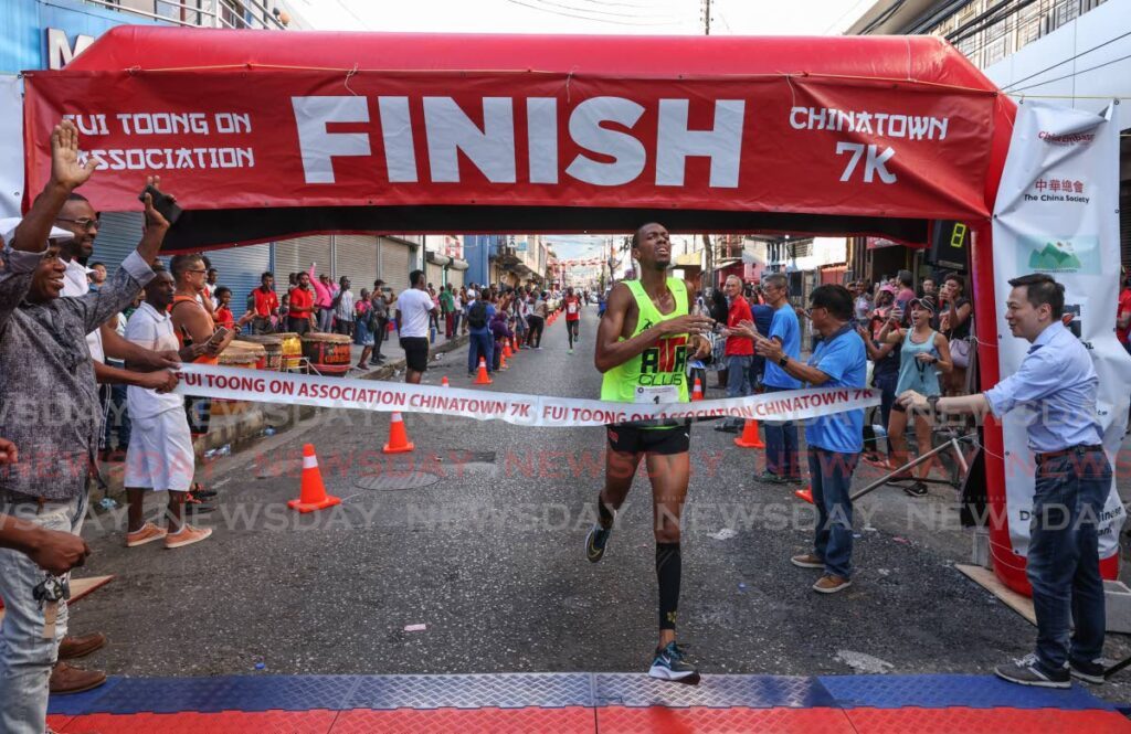 Nicholas Romany crosses the finish line to win the Chinatown 7K on Charlotte Street, Port of Spain on Sunday. - Photo by Jeff K Mayers