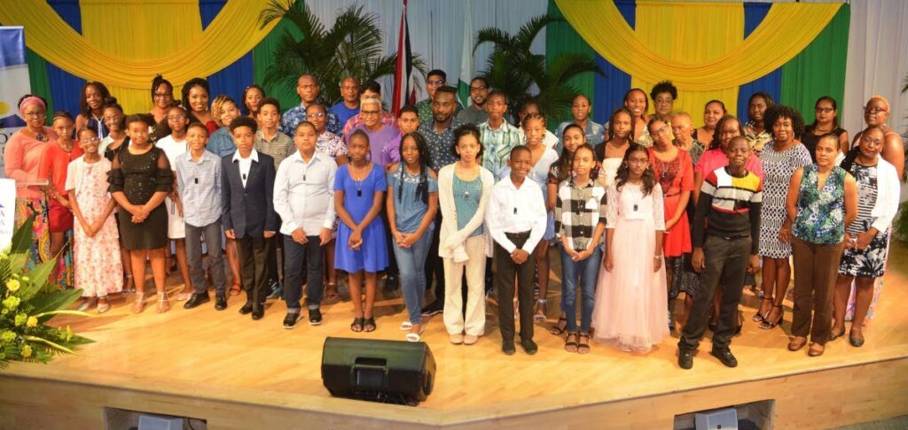Parents of students who received SEA awards from Agricola Credit Union Co-operative Society join them on stage for a group photo following the ceremony at the Government Campus Plaza Auditorium in Port of Spain. - Overtime Media