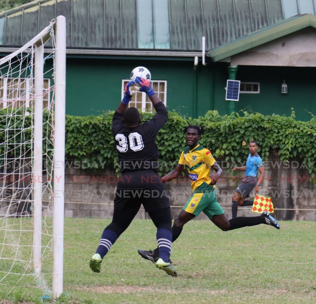 San Juan North goalie Stephon Langaigne saves a header from St Benedict's Jaden Grant in a Secondary Schools Football League clash at San Juan grounds on Wednesday.  - ROGER JACOB