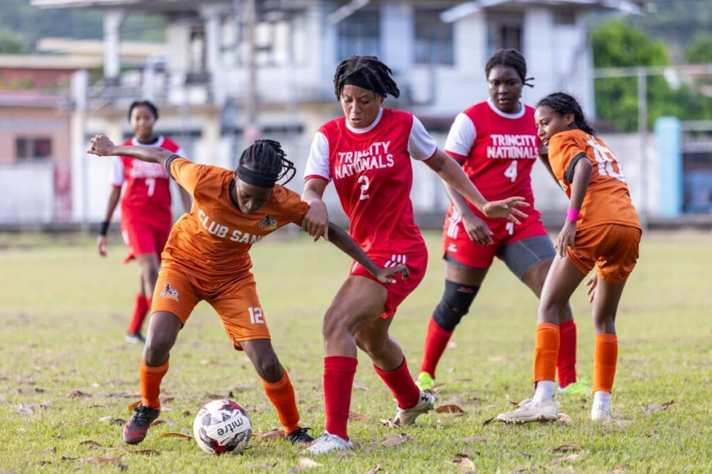 A Club Sando player, left, dribbles the ball against Trincity Nationals in a Women's League Football clash on Sunday at the Eddie Hart Recreation Ground, Tacarigua. - TT WoLF