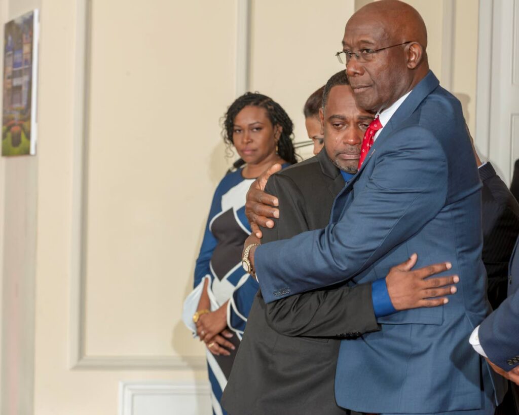 CONSOLED: Prime Minister Dr Keith Rowley consoles a weeping Kelvin Bhagwandeen who received the Hummingbird Medal (Bronze) on behalf of his daughter Rachel, 11, who died while saving her younger brother from a dog attack in August 2022. The national awards ceremony was held on Sunday at President's House. Photo courtesy the Office of the President.
