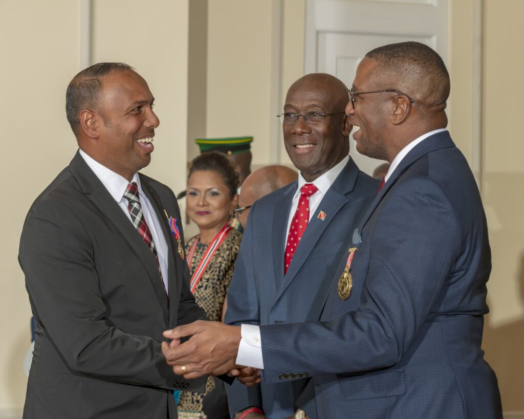 At left, Samuel Badree, received the Hummingbird Medal Gold, in the sphere of sports, congratulated by PM Keith Rowley and CJ Ivor Archie. - Photo courtesy Office of the President