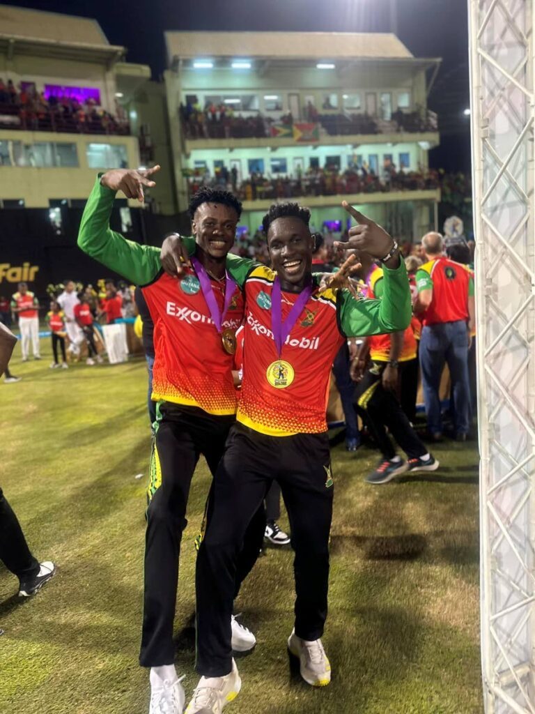 Guyana Amazon Warriors players Junior Sinclair, left, and Kevlon Anderson celebrate with their medals after winning the Republic Bank Caribbean Premier League final on Sunday night at Providence Stadium, Guyana. - 