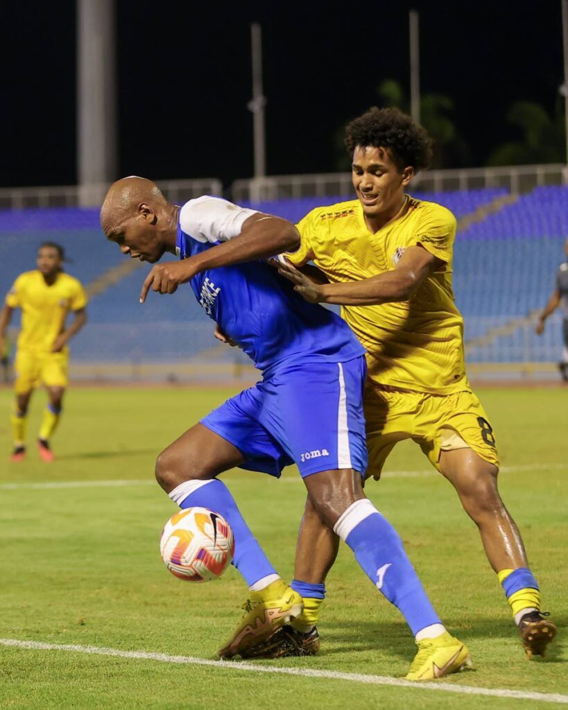 Defence Force FC Brent Sam (L) holds off Athletic Club PoS' Michel Poon Angeron during the Concacaf Caribbean Cup at the Hasely Crawford Stadium on Thursday in Port of Spain. The match ended 1-1.  - Daniel Prentice