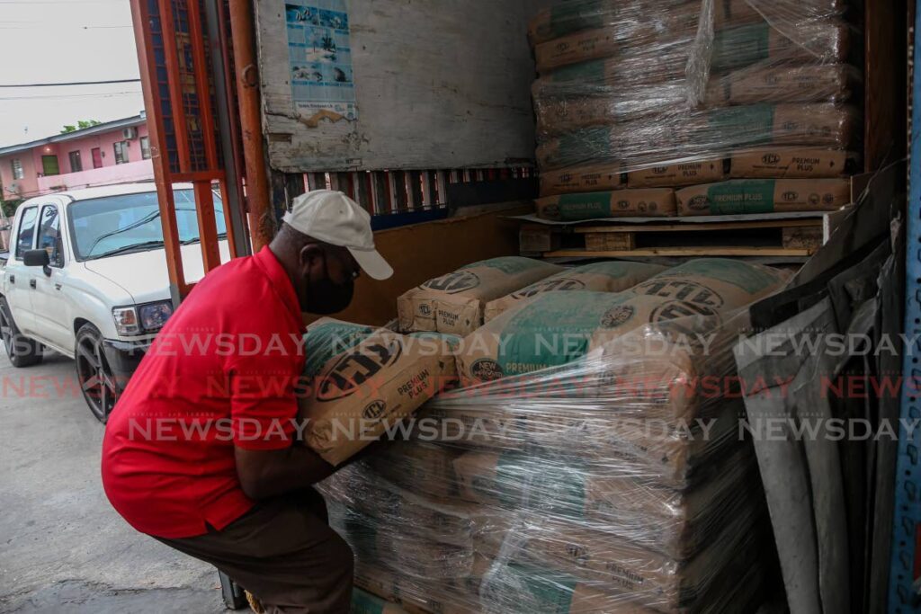 A hardware worker in Chaguanas removes a bag of TCL cement for a customer. Photo by Jeff K. Mayers