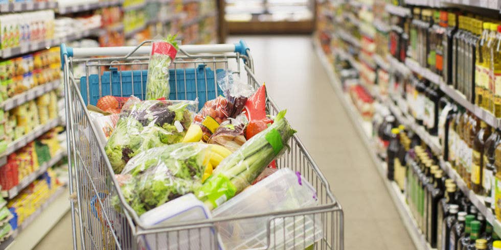 A shopping cart filled with fresh produce. - 