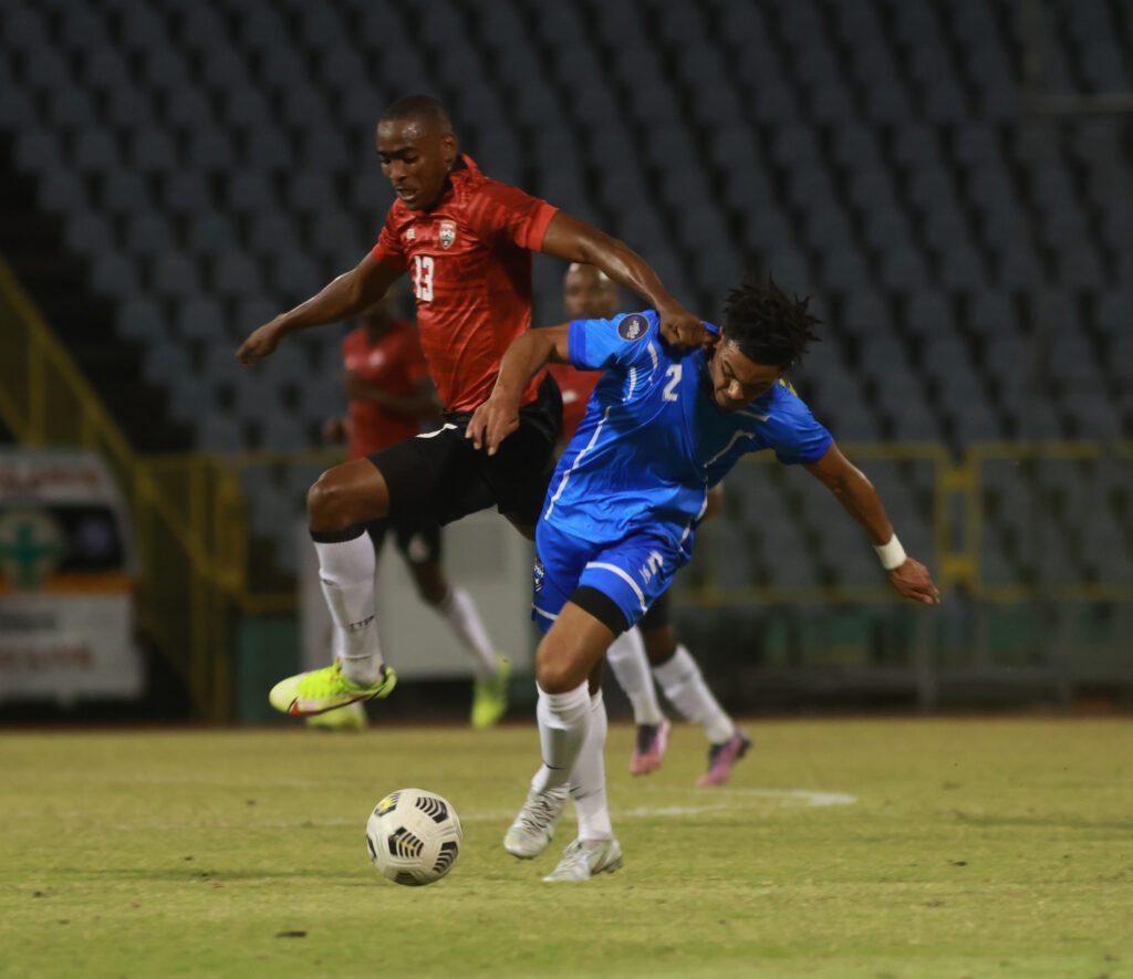 Trinidad and Tobago's Reon Moore, left, tussles for the ball with St Martins Stephan Varsovie during a friendly match at the Hasely Crawford Stadium, Mucurapo, Sunday. TT won 2-0.
