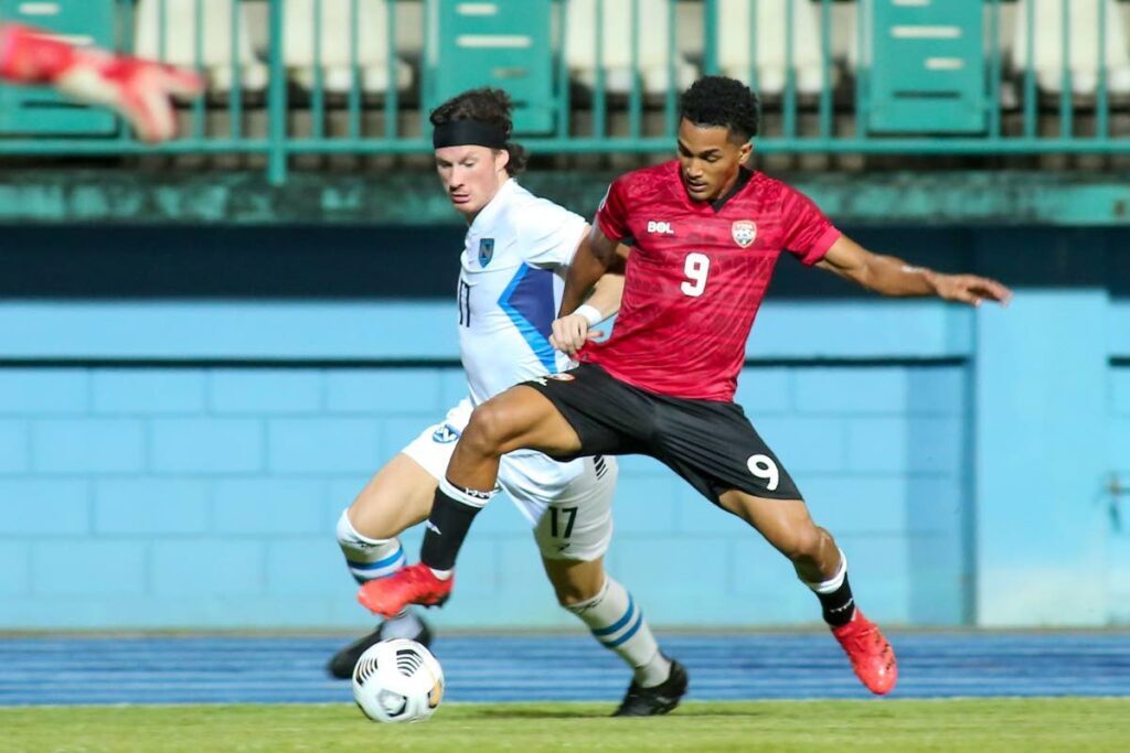 Trinidad and Tobago midfielder Michel Poon-Angeron, right, fights for the ball against Nicaragua. - 