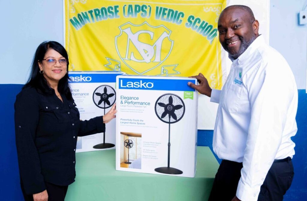 Sagicor unit manager Ephraim Thompson, right, from the Chaguanas branch donates fans to principal Ranu Jadoo of Montrose Vedic School. - 