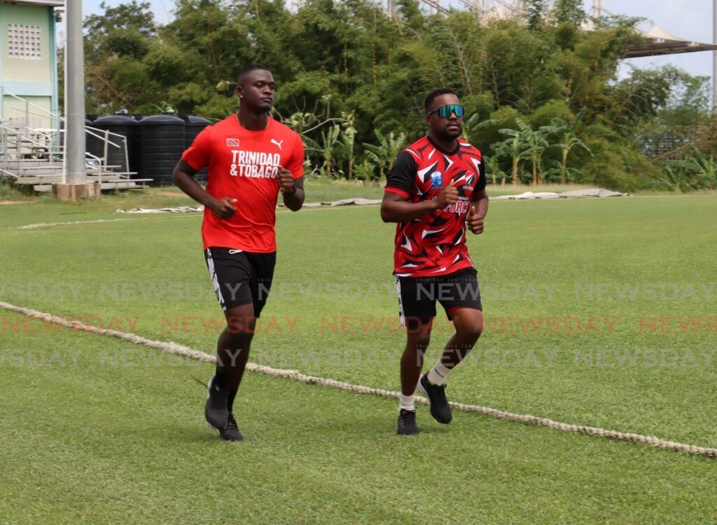 Red Force captain Darren Bravo, right, and bowler Jayden Seales jog around the field at the National Cricket Centre, Balmain, Couva, Friday. - Photo by Roger Jacob