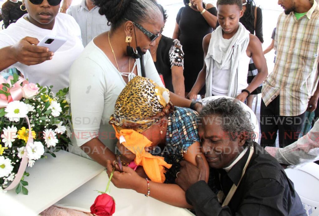 GONE TOO SOON: Parents of murdered teen Andrea Lallan, Eddie Lallan and Christine 
Phillip, comfort each other during her funeral at Old Mayaro Road, Libertville, Rio Claro, on 
Thursday. - AYANNA KINSALE