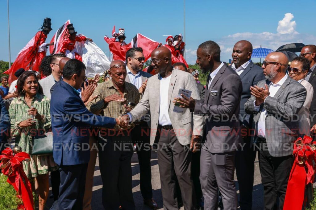 Prime Minister Dr Keith Rowley, centre, congratulates Works Minister Rohan Sinanan after the commissioning of Solomon Hochoy Highway extension to Point Fortin on Saturday.  - Jeff K. Mayers