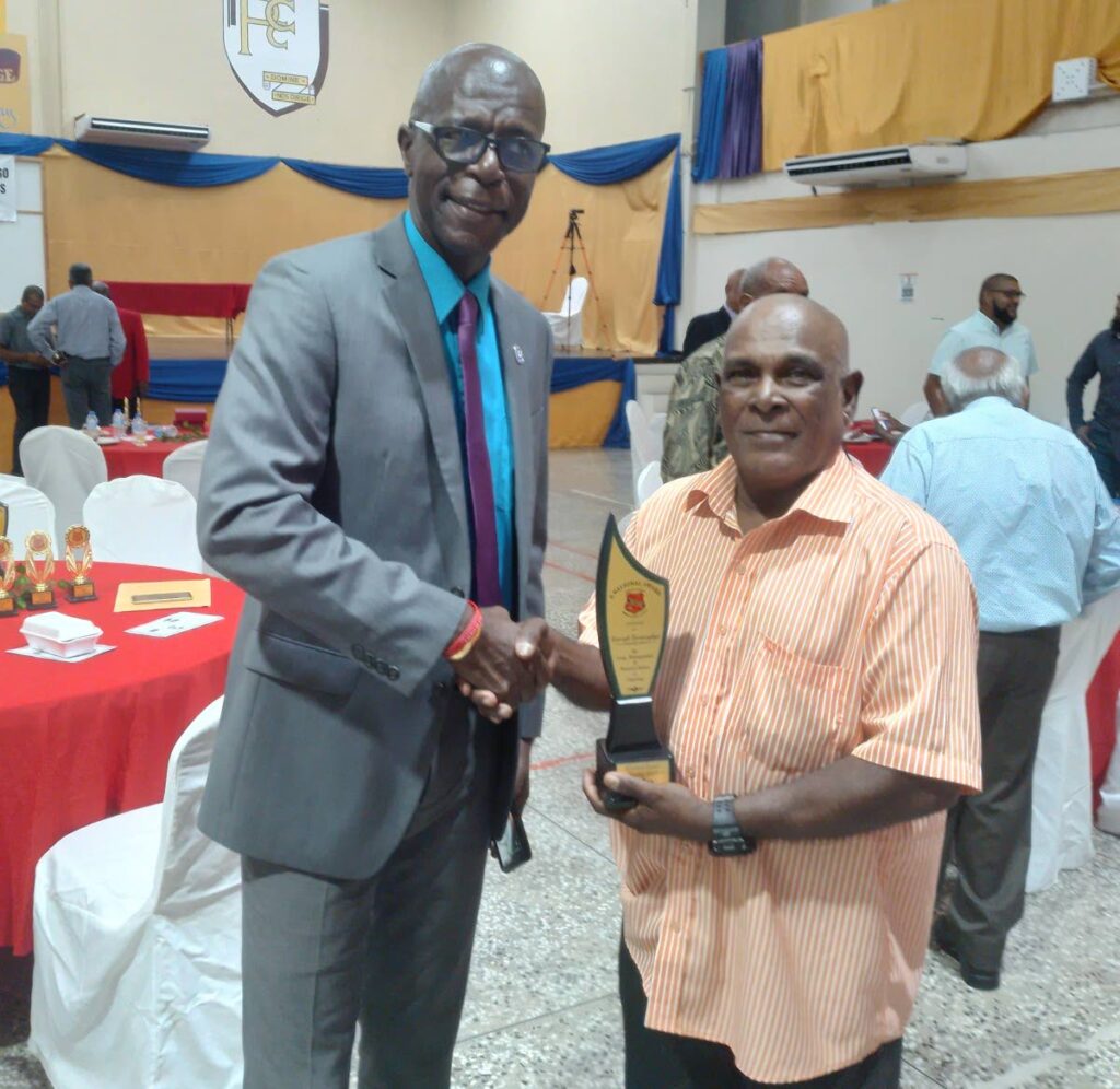 Retired umpire Kimrajh Barrsinghga, right, shakes the hand of international umpire Peter Nero at a TT Cricket Umpires Council awards function over the weekend. - 