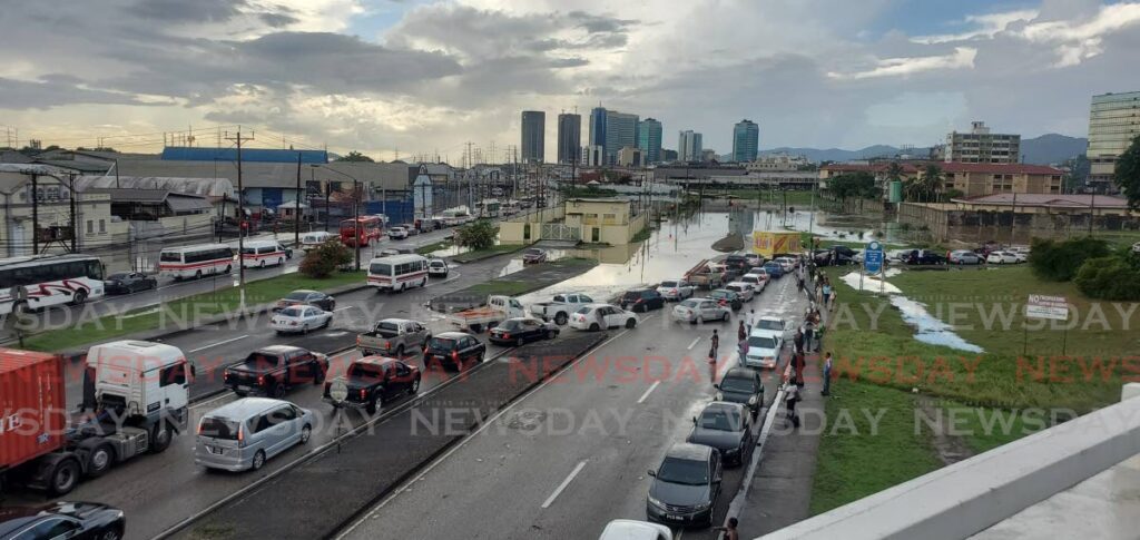 Drivers try to make their way into Port of Spain through floodwaters after heavy rain on October 18.  - DENNIS ALLEN