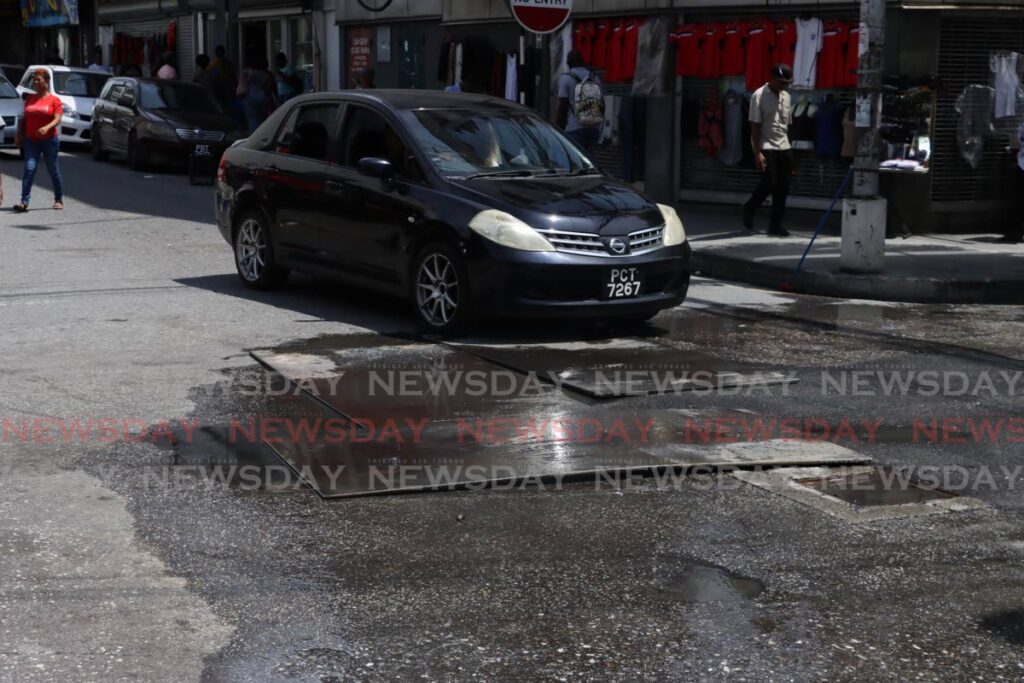 The cast-iron pipeline at the corner of Frederick and Queen Street, Port of Spain, which was repaired on October 16 and 17 by WASA employees, has reappeared. - Photo by Roger Jacob