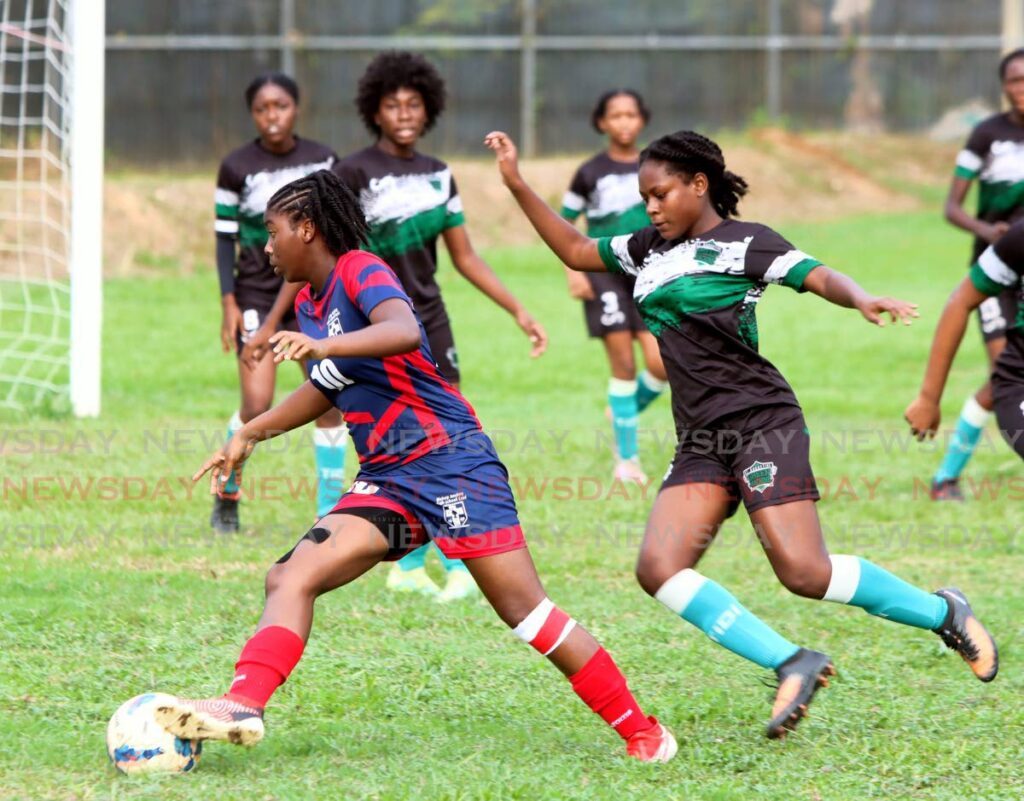 Orielle Martin of Bishop Anstey High School East, left, turns towards goal as Felicia Rocke of St Augustine Secondary School defends, during their Secondary School Football League Championship match, at St Augustine Secondary School on Sunday.  - ANGELO MARCELLE