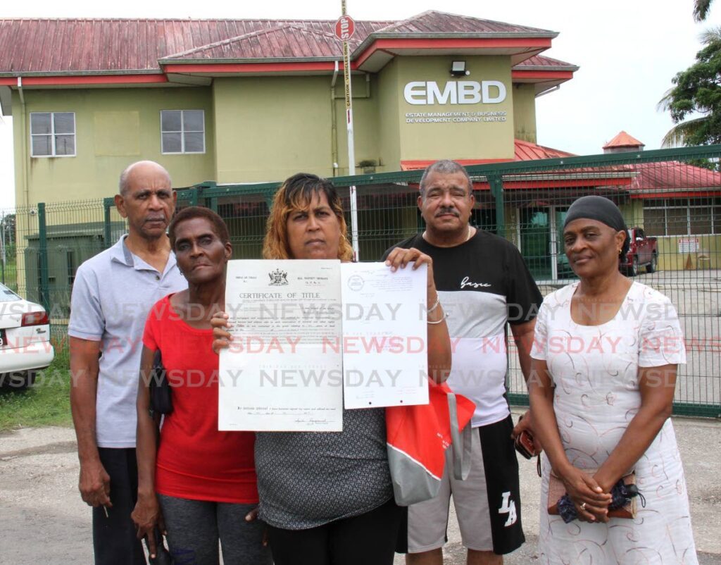 Claxton Bay resident Nardera Ramsaran-Williams displays her deed during a protest at EMBD office Brechin Castle, Couva. Also in the photo, from left, Allan Miller, Marva Fritz, Giles Garcia and Julia Miller.  - Photo by Ayanna Kinsale