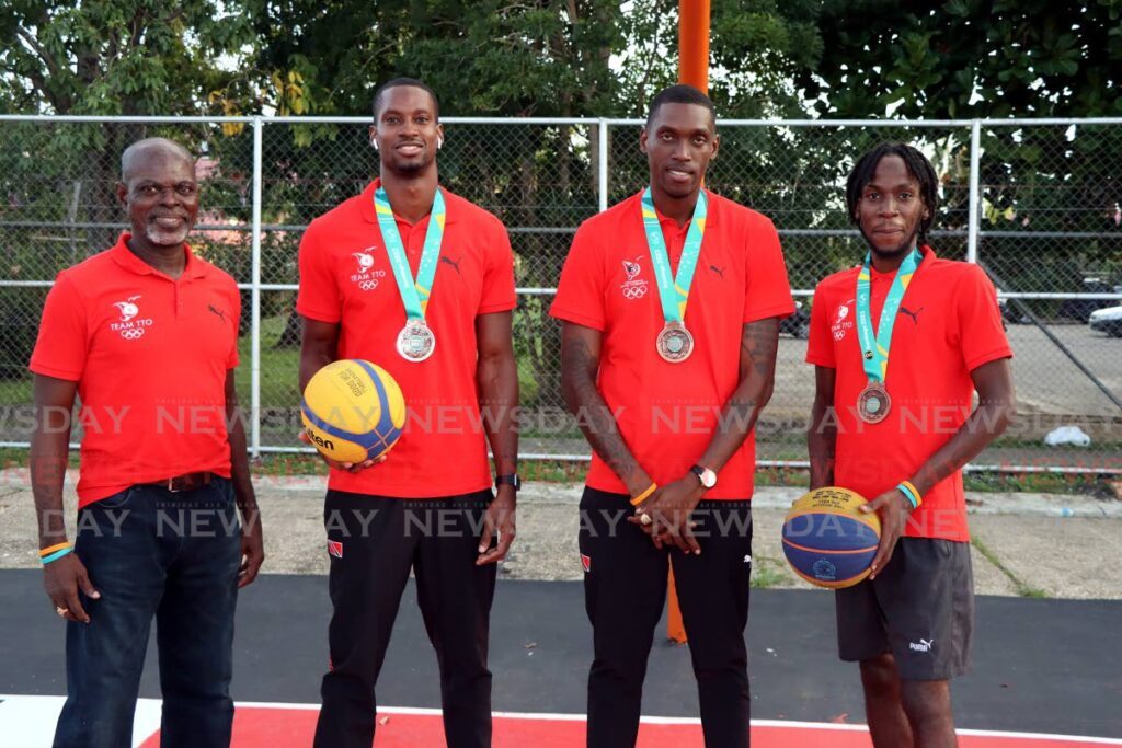 (L-R) Basketball coach Christopher Jackson Charles stands alongside TT 3x3 men’s team players  Chike Augustine, Moriba De Freitas and Ahkeem Boyd at the Maloney Basketball outdoor court,on Thursday. - 