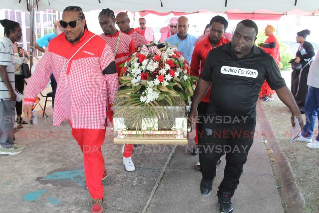 JUSTICE FOR KERN: Kern Ettienne’s twin brother, Kerdell Ettienne, right, and other pallbearers carry Kern’s body to the funeral service at the Embacadere community centre. - Photo by Lincoln Holder