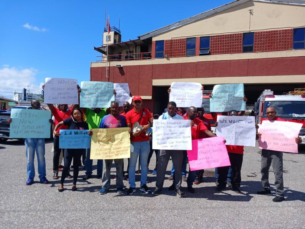 Head of the Fire Services Association, Leo Ramkissoon (centre), protests outside the Wrightson fire station with retired fire officers. - Photo by Joey Bartlett