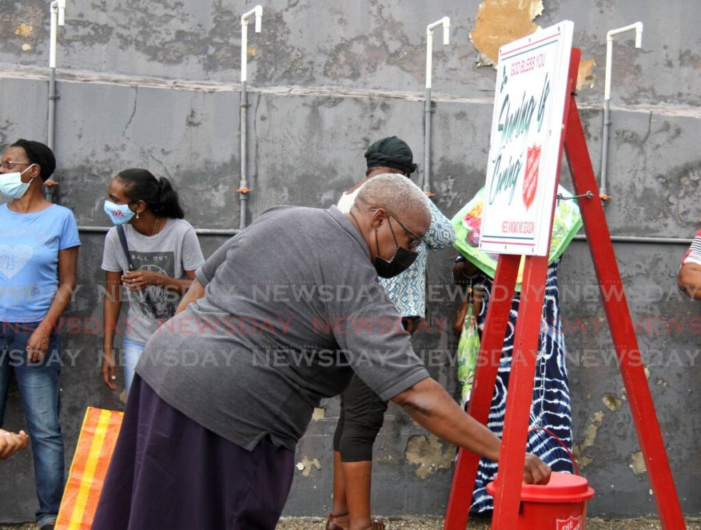 A woman places her donation in a Salvation Army Christmas kettle at the Salvation Army Headquarters on Henry Street, Port of Spain, in December 2022. FILE PHOTO/AYANNA KINSALE - 