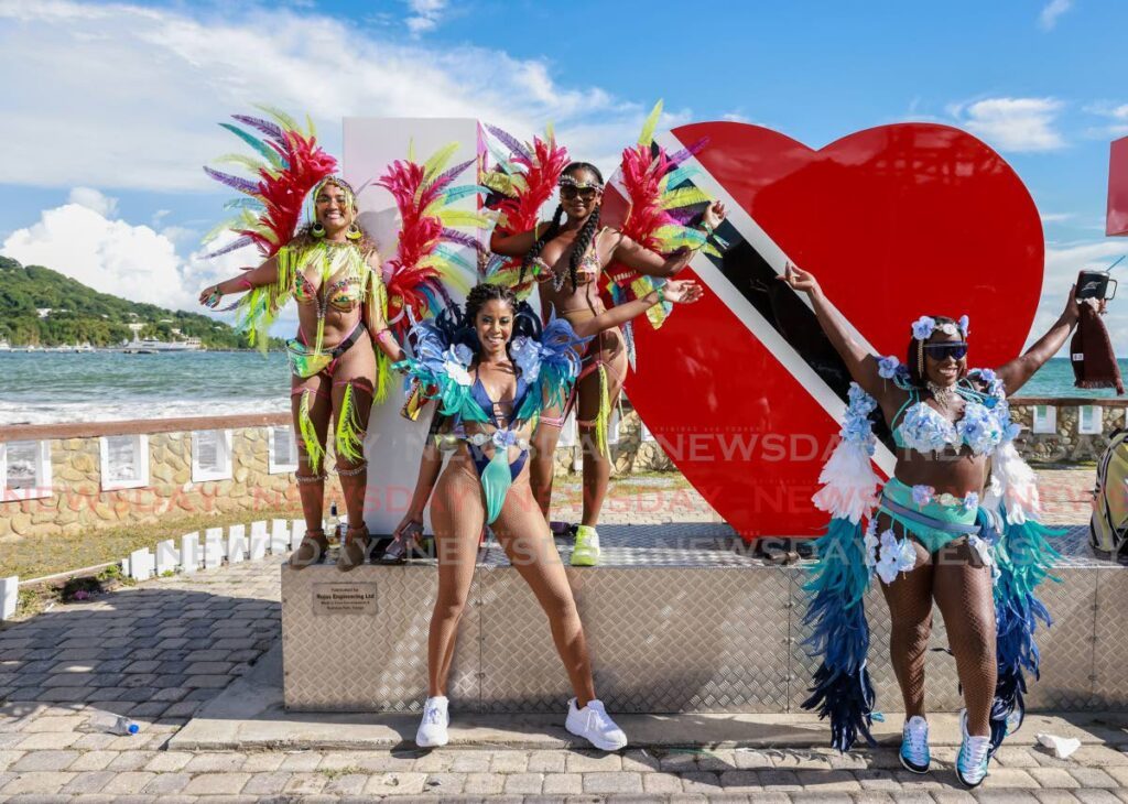 Masqueraders from the band Zain Carnival Experience pose for the camera. - Jeff K. Mayers