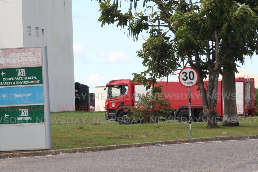 Fire officers on the compound of  Heritage Petroleum at Pointe-a-Pierre  where a fire was reported to have started in the administration building. No injuries were reported. - Photo by Lincoln Holder