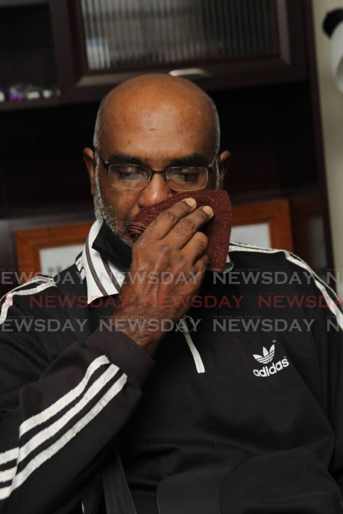 Retired police officer Bissondath Samaroo wipes away tears during a press conference at the law office of Prakash Ramadhar, Lord Street, San Fernando, on Wednesday. - Lincoln Holder