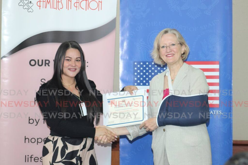Daniela Cumana, one of the participants in the course, receives her certificate from Kirsten Michener public affairs officer, US embassy.