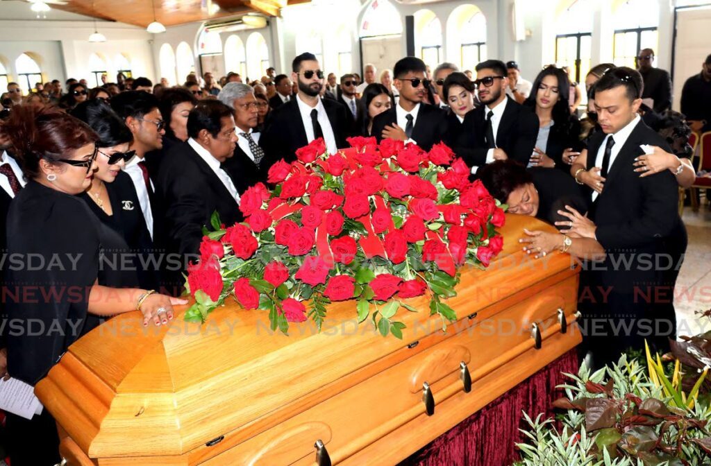 Family members surround the casket of business tycoon Helen Bhagwansingh during her funeral on Sunday at the Aramalaya Presbyterian Church in Tunapuna. PHOTO BY ROGER JACOB - ROGER JACOB