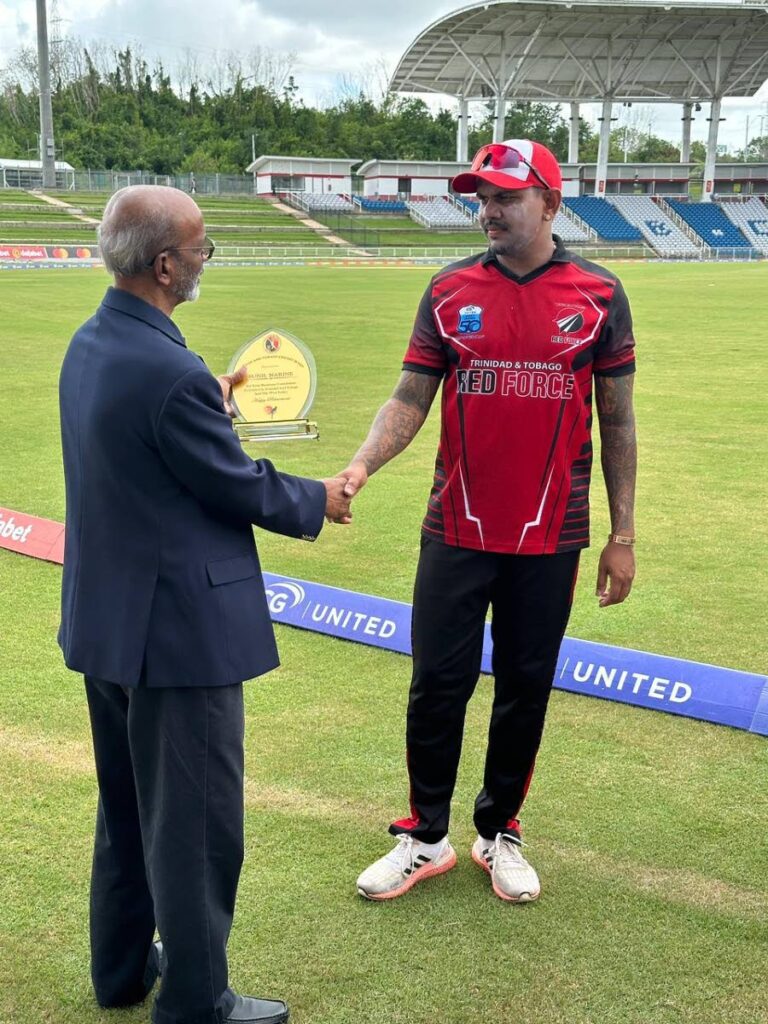Sunil Narine, right, is presented with a commemorative plaque from the TT Cricket Board by first vice-president Arjoon Ramlal at the Brian Lara Cricket Academy on Wednesday.  - courtesy TTCB
