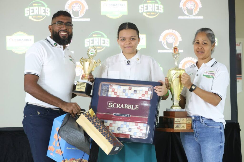 Jada Marie Pierre of St Joseph’s Convent, St Joseph, middle, collects her award after winning the senior individual category at the National Secondary Schools Scrabble Championships. At left is vice-president of Subway Johann Mendoza and at right is a representative from the Trinidad and Tobago Scrabble Association. - 