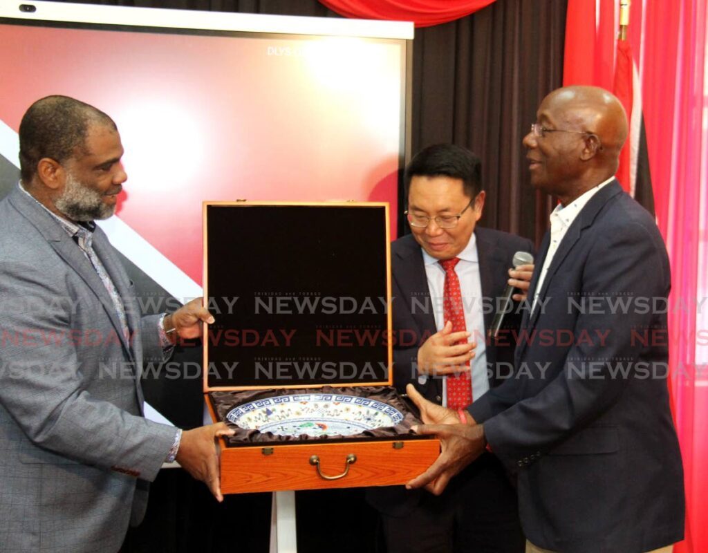 Prime Minister Dr Keith Rowley, right, receives a token from Enterprise Business director trinidad and Tobago Tudor john  during the Huawei IdeaHub donation ceremony at the Carenage Police Youth Club and Homework Centre, Constabulary Street, Carenage. Looking on is President of Hiawei Technologies Daniel Zhou.  - Ayanna Kinsale