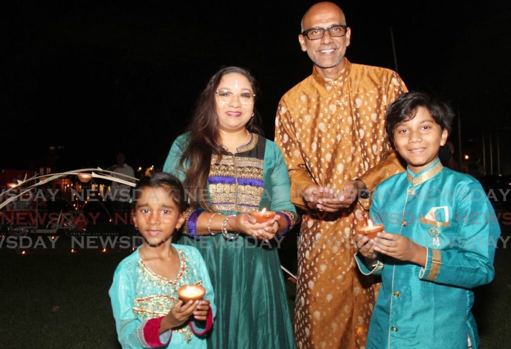 Port of Spain City Corporation Councillor Jameel Bisnath, his wife, Chantal and his children Zahra and Zahid hold lighted deyas at the corporation's Divali celebration at Woodford Square, on Saturday night. - Ayanna Kinsale
